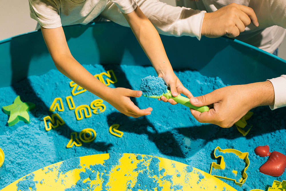 "Interactive Kinetic Sand Play: Collaborative Fun with Colorful Molds"